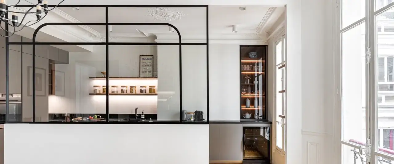 Cocina semiabierta cristal con estantes iluminados, vajilla y vinoteca.